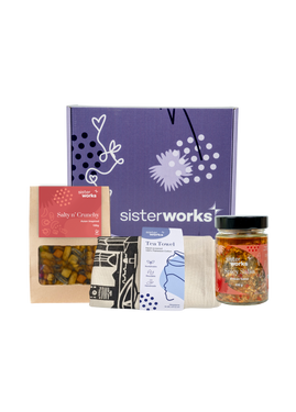 An overhead view of the open SisterWorks Savoury Treats Hamper. The box contains a colourful tea towel, a jar of SisterWorks Spicy Salsa, and a bag of Salty n' Crunchy Mix, all arranged to showcase a collection of gourmet, savoury snacks. An overhead view of the open SisterWorks Savoury Treats Hamper. The box contains a colourful tea towel, a jar of SisterWorks Spicy Salsa, and a bag of Salty n' Crunchy Mix, all arranged to showcase a collection of gourmet, savoury snacks.