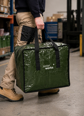 Worker carrying zipped heavy-duty storage bag in warehouse setting