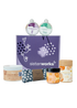 An overhead view of the open SisterWorks Aromatherapy Bliss Hamper. The contents are neatly arranged inside a box, including a pouch of Masala Chai, a Lavender Escape Shower Steamer, a Menthol Revival Shower Steamer, a Forest Trails Candle, an eye pillow, and a jar of uplifting bath salts, highlighting an ethical gift set for relaxation and self-care.
