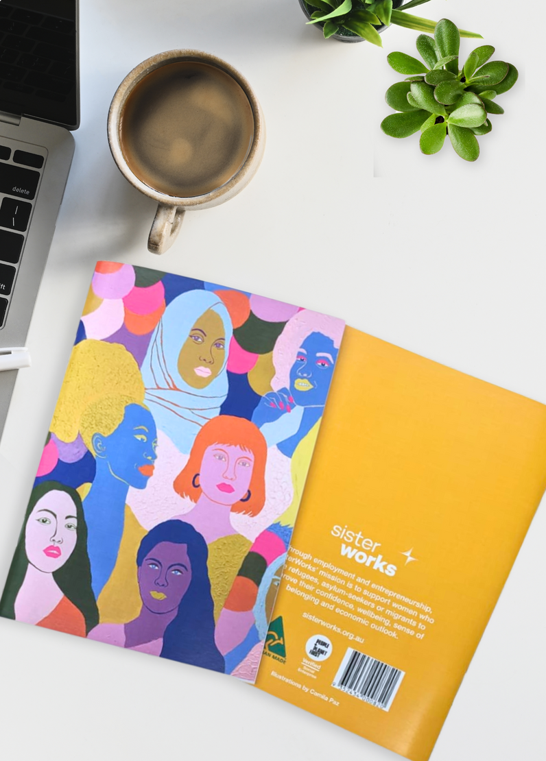 A front-facing view of the SisterWorks Women of the World Notebook. The notebook features a colourful and artistic illustration of diverse women from various cultures. The SisterWorks logo is visible, highlighting its role as a purposeful, ethical journal.