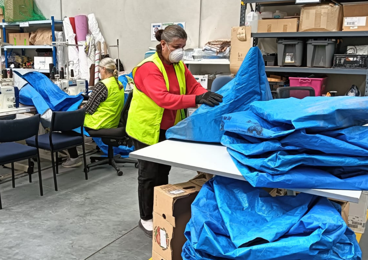 Women producing upcycled tarpaulin products at SisterWorks