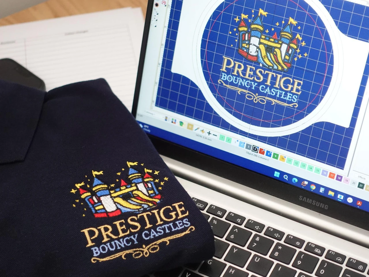 A digitised embroidery file open on screen beside the finished garment — the same logo stitched onto a navy polo shirt