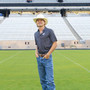 Antigua dark Texas A&M polo featuring an allover small geometric print, classic collared neckline, short sleeves, and an embroidered white A&M logo on the chest for a polished Aggie look.