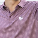 Antigua maroon Texas A&M polo featuring an allover small geometric pattern, classic collared neckline, short sleeves, and an embroidered white A&M logo on the chest for polished Aggie style.