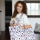 Ida Mae quilted tote bag featuring maroon floral designs, green botanical accents, black decorative detailing, a white background, quilted construction, and double shoulder straps for everyday carrying.