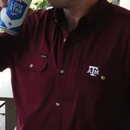 Poncho maroon Texas A&M short sleeve button-down shirt featuring dual chest pockets, an embroidered A&M logo, button closures, collared design, and a built-in white lens cloth for sunglasses.