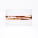 A Wink of Yellow set of six thin beaded bracelets featuring assorted maroon, white, and metallic gold seed bead patterns, displayed together as a coordinated layered bracelet stack.