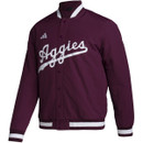 Maroon adidas Texas A&M varsity jacket featuring white “Aggies” script across the chest with striped ribbed trim and snap front closure, styled as a classic Aggies game day outerwear piece.