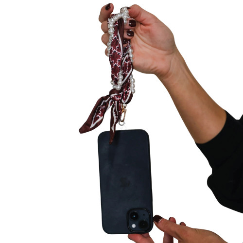 Victory Lap Texas A&M Aggies maroon and white woven wrist strap with pearl accents attached to phone case.