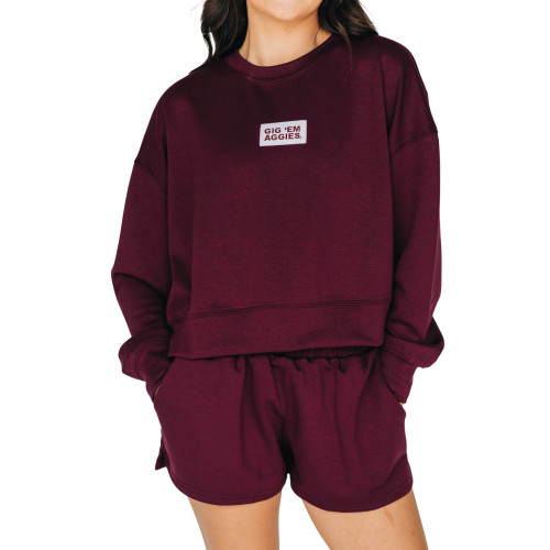 Scarlet & Gold Texas A&M maroon cropped crewneck sweatshirt featuring a white Gig ’Em Aggies patch on the chest, styled with matching maroon shorts.