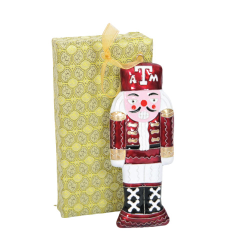 Kitty Keller Texas A&M Aggies nutcracker ornament in maroon and white uniform with ATM logo on hat and decorative gift box behind.