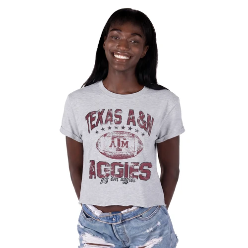 ZooZatz Texas A&M light gray cropped tee featuring rolled short sleeves and a distressed maroon football graphic with Texas A&M, A&M logo, stars, Aggies, and Gig ’Em Aggies lettering.