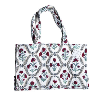 Ida Mae quilted tote bag featuring maroon floral designs, green botanical accents, black decorative detailing, a white background, quilted construction, and double shoulder straps for everyday carrying.