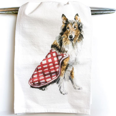 Taylor Paladino tea towel featuring an illustration of Reveille wearing a maroon gingham bandana on a white towel, creating a charming Texas A&M-inspired kitchen accessory.