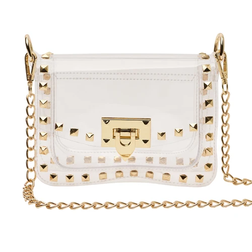 Clear structured crossbody bag featuring gold-tone pyramid studs around the edges, a polished gold clasp closure, transparent flap front, and removable gold chain shoulder strap for game days and events.
