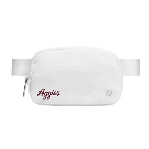 White lululemon belt bag featuring a maroon script Aggies logo on the lower left front, subtle lululemon logo on the lower right, zippered main compartment, and matching adjustable strap.