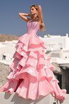 Model in pink PS26253 showcasing layered ruffle ball gown skirt and structured bodice.