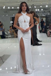 White Jasz Couture 7904 gown shown on runway with crisscross halter neckline, keyhole bodice, and high slit.