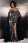 Model wearing black Jasz Couture 7938 with off-the-shoulder beaded bodice, cape sleeves, and thigh-high slit.