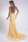 Back view of the yellow lace gown showing the open back and scalloped lace hem.