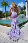 Back view of the lilac lace gown featuring a low open back and flowing lace train.