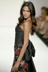 Sherri Hill 67204 side view in Black Print with dramatic taffeta cape and basque waistline detail.