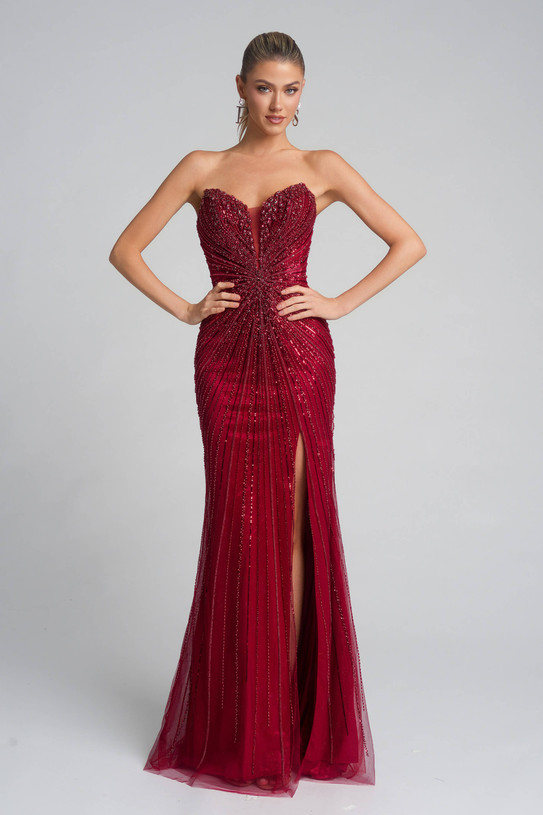 Model wearing Portia and Scarlett PS26237 red fully beaded fitted prom dress with strapless sweetheart neckline, waist ruching, and thigh-high slit