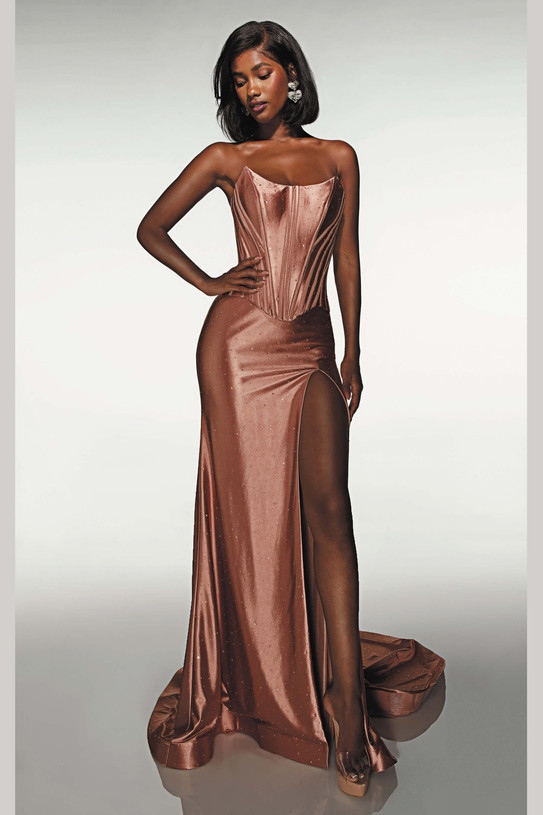 Front view of a fitted strapless rose gold rhinestone stretch jersey gown featuring a scoop neckline, structured corset bodice, thigh-high slit, and sleek floor-length skirt.