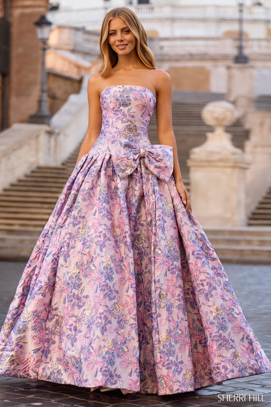 Sherri Hill 57781 in Lilac Print with strapless neckline, side bow detail, and pleated ballgown skirt.