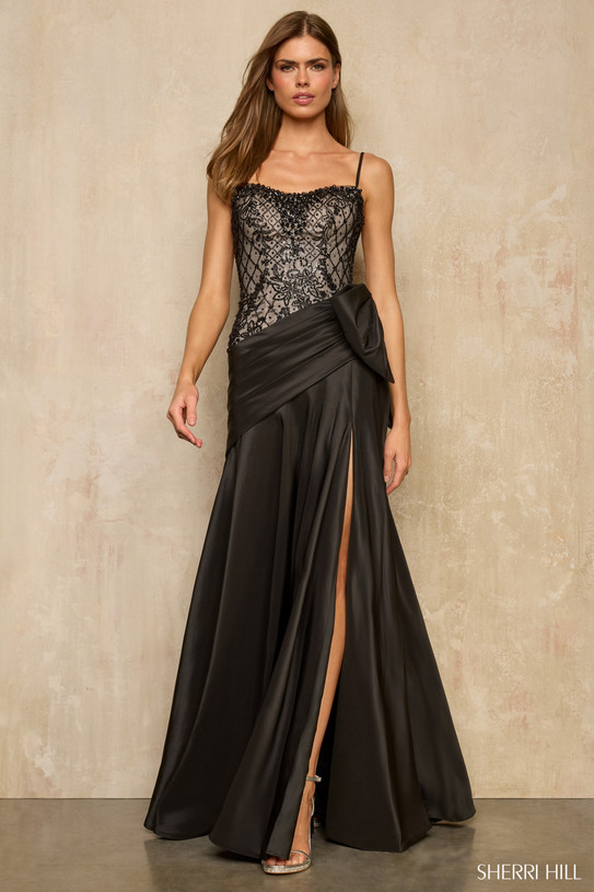 Sherri Hill 57960 in black with beaded lace bodice and asymmetrical bow waist detail.