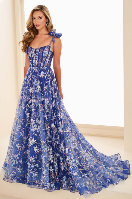 Royal Blue/Multi Ellie Wilde EW37020 floral A-line prom gown with corset bodice and bow straps. Royal Blue/Multi Ellie Wilde EW37020 floral A-line prom gown with corset bodice and bow straps.