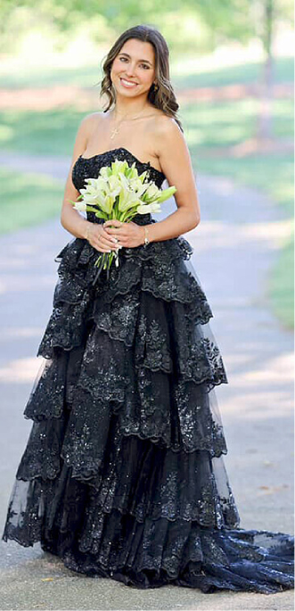 Student in layered black gown holding flowers