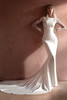 This sleek gown features delicate lace sleeves and side detailing for a refined, modern bridal look