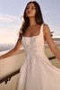 Leafy lace appliqué and beaded texture frame a modern square neckline