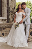 Plus-size bride wearing the Maggie Sottero Skylar A-line gown with off-the-shoulder draped sleeves in a romantic setting.