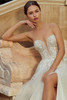 Bride in Raphaella seated, highlighting floral corset bodice and tulle skirt.