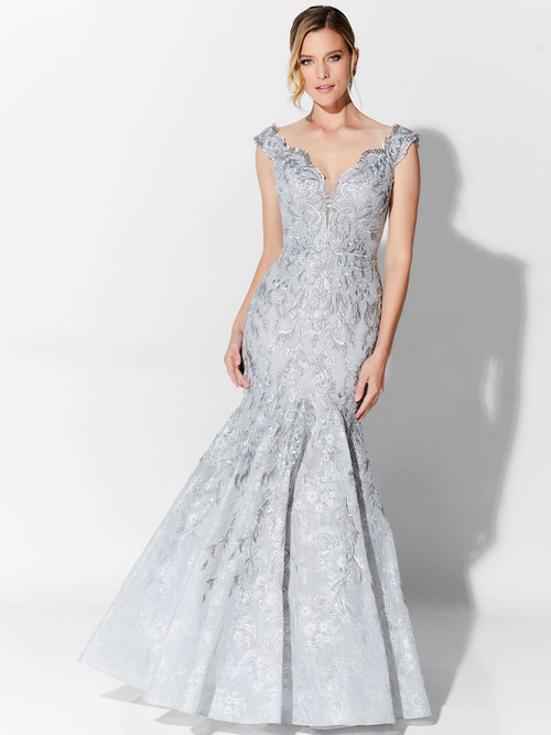 Silver embroidery shimmers on this trumpet gown with illusion plunge and scalloped cap sleeves Silver embroidery shimmers on this trumpet gown with illusion plunge and scalloped cap sleeves