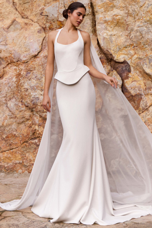 Front view of Pronovias Rendra crepe fit-and-flare wedding dress with sculpted peplum and chiffon cape