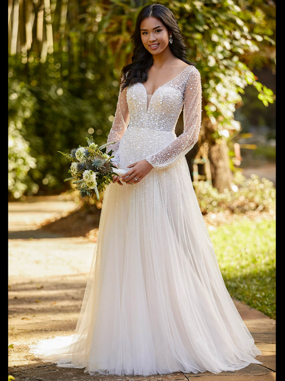 Sparkling pearl beading and sheer sleeves add ethereal charm to this flowing tulle A-line gown Sparkling pearl beading and sheer sleeves add ethereal charm to this flowing tulle A-line gown