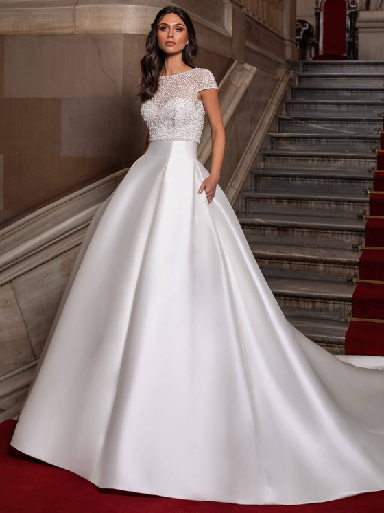 Regal meets radiant in this satin ball gown with a pearl-encrusted illusion bodice and hidden pockets Regal meets radiant in this satin ball gown with a pearl-encrusted illusion bodice and hidden pockets