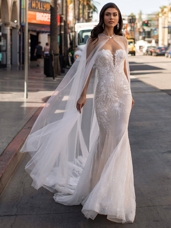 Strapless fitted gown with shimmering beadwork, feather-like embroidery, and detachable flowing tulle cape overlay Strapless fitted gown with shimmering beadwork, feather-like embroidery, and detachable flowing tulle cape overlay