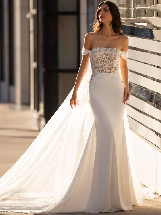 Fitted gown with sheer lace bodice, detachable off-shoulder tulle sleeves with a dramatic overskirt train Fitted gown with sheer lace bodice, detachable off-shoulder tulle sleeves with a dramatic overskirt train