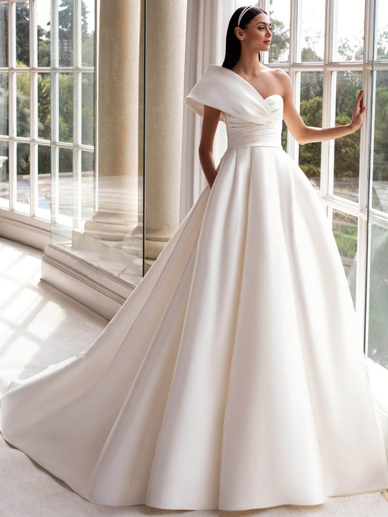 Modern ball gown with a sculpted one-shoulder neckline, pleated bodice, and full mikado skirt Modern ball gown with a sculpted one-shoulder neckline, pleated bodice, and full mikado skirt