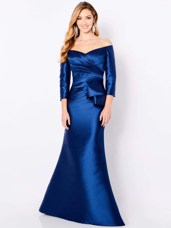 Satin navy gown with off-shoulder neckline, pleated bodice, and peplum waist detail Satin navy gown with off-shoulder neckline, pleated bodice, and peplum waist detail