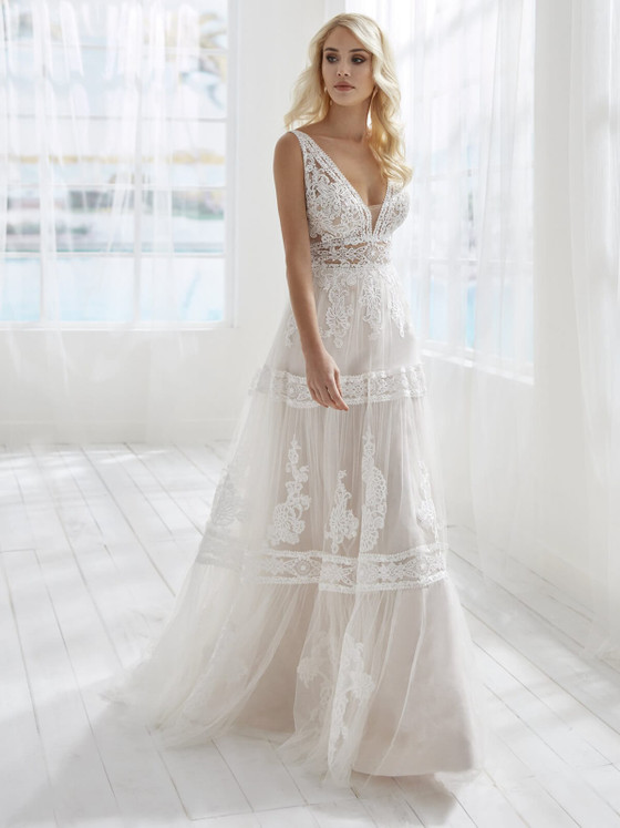Romantic A-line lace gown with a plunging neckline, sheer bodice, and soft tiered tulle skirt. Romantic A-line lace gown with a plunging neckline, sheer bodice, and soft tiered tulle skirt.