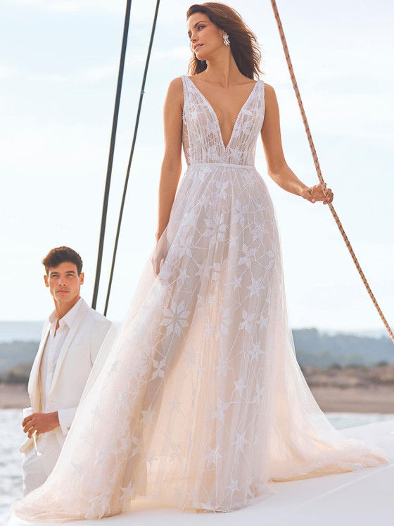 A dreamy A-line gown with a plunging neckline and starry lace overlay, perfect for seaside vows A dreamy A-line gown with a plunging neckline and starry lace overlay, perfect for seaside vows