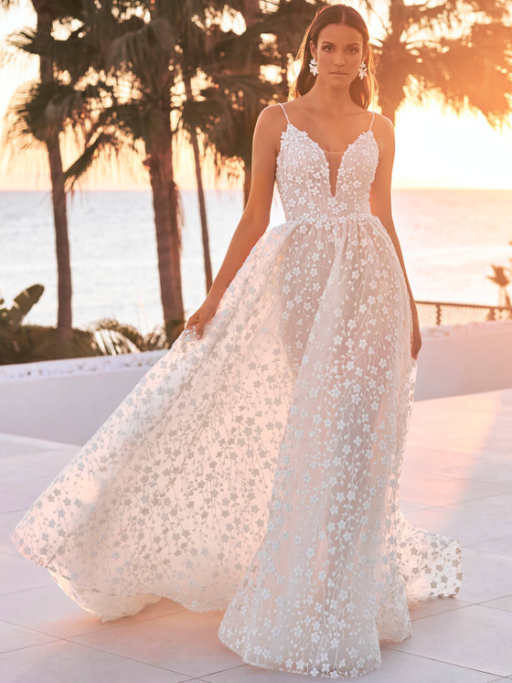 Spaghetti strap gown with delicate floral lace overlay and a flowing, ethereal skirt perfect for a romantic sunset ceremony Spaghetti strap gown with delicate floral lace overlay and a flowing, ethereal skirt perfect for a romantic sunset ceremony