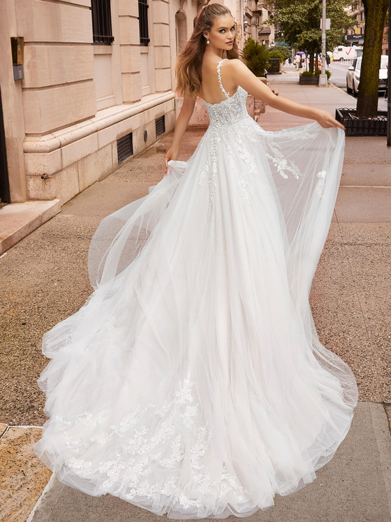 Bride twirling in Morilee Johanna A-line gown with billowing tulle skirt on a city street. Bride twirling in Morilee Johanna A-line gown with billowing tulle skirt on a city street.
