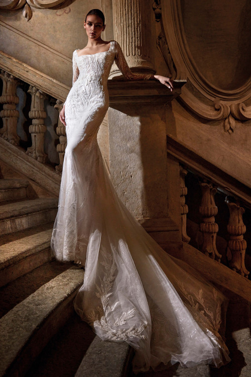 Regal fit-and-flare gown with a square neckline, illusion lace sleeves, and an embroidered cathedral train Regal fit-and-flare gown with a square neckline, illusion lace sleeves, and an embroidered cathedral train