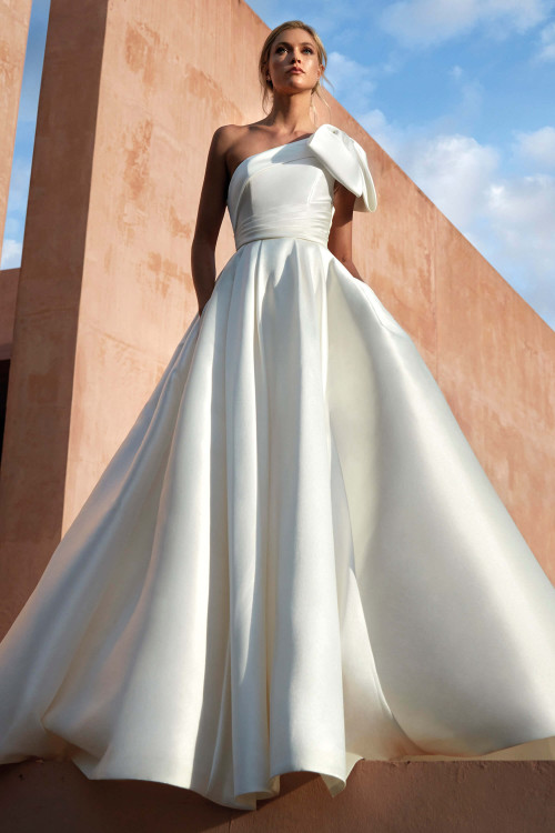 Chic one-shoulder mikado ballgown with a statement bow and pleated waistline for timeless elegance Chic one-shoulder mikado ballgown with a statement bow and pleated waistline for timeless elegance